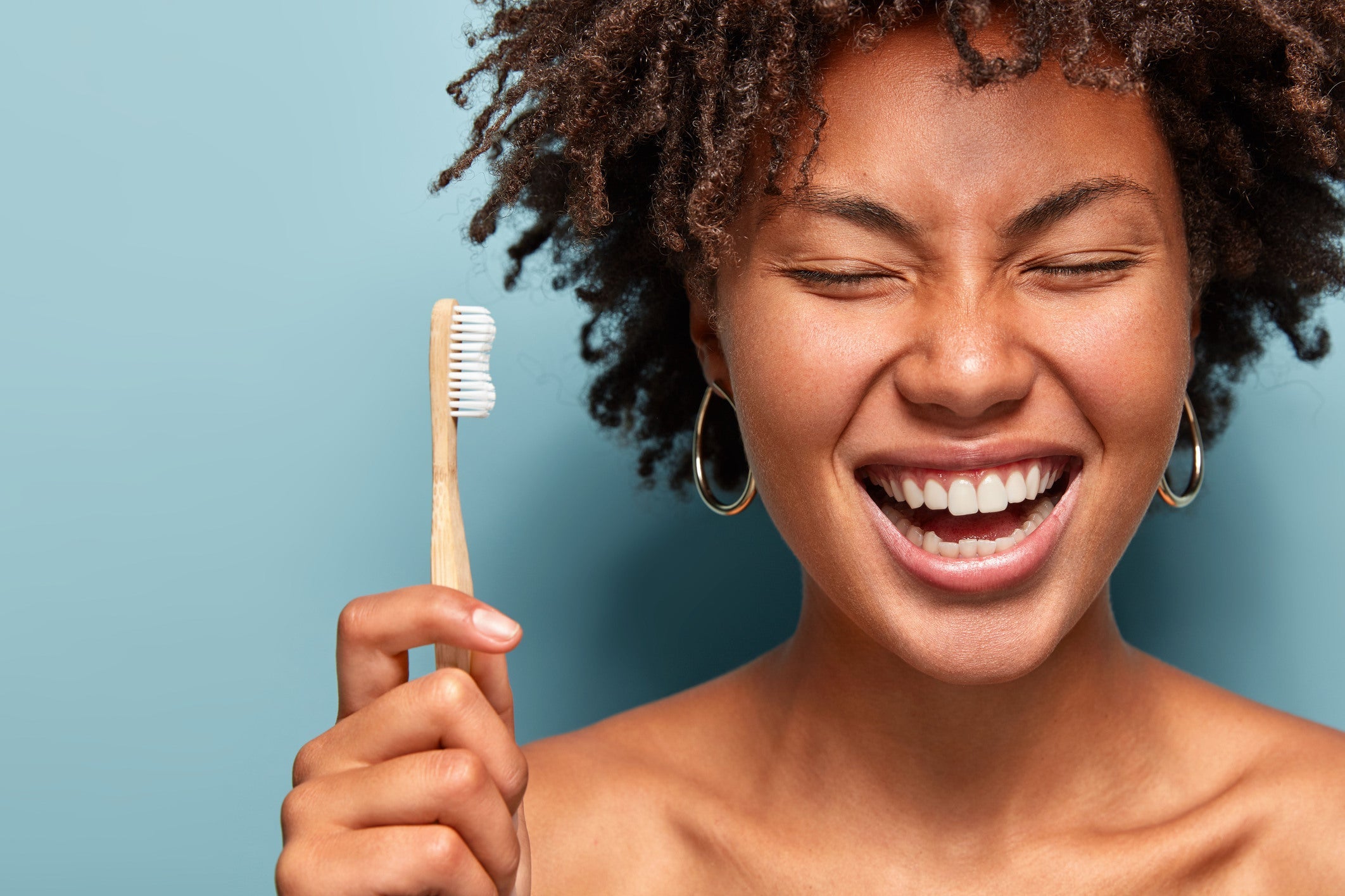 Women Holding a Toothbrush with A Big Smile by WHstudio Leushin N